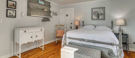 A bedroom with a bed, dresser, chair, and bedside tables.