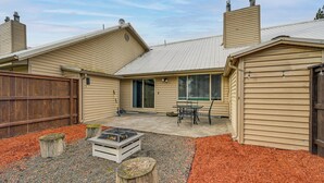 A house with a covered patio, a fire pit, and a wooden fence. - Near Mcnary Dam! Pet-friendly Condo on Golf Course (Umatilla)