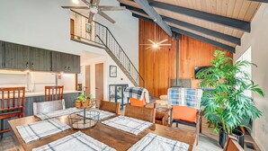 A spacious living area with a wooden dining table set for four, a staircase, and a large potted plant. - Near Mcnary Dam! Pet-friendly Condo on Golf Course (Umatilla)