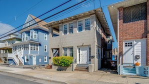 A row of residential buildings with a central two-story house featuring a front porch, a small garden, and a mailbox. - 2 Blocks to Ventnor City Beach: Pet-friendly Gem! (Ventnor City)