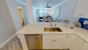 A modern kitchen with a dishwasher, a sink, and a ceiling fan. - Destin On The Gulf 506 2 Bedroom Condo (Destin)