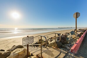 A coastal access sign warning of steep stairs and potential risks. - Stroll to Shore: Oceanside Condo w/ Hot Tub Access (Oceanside)
