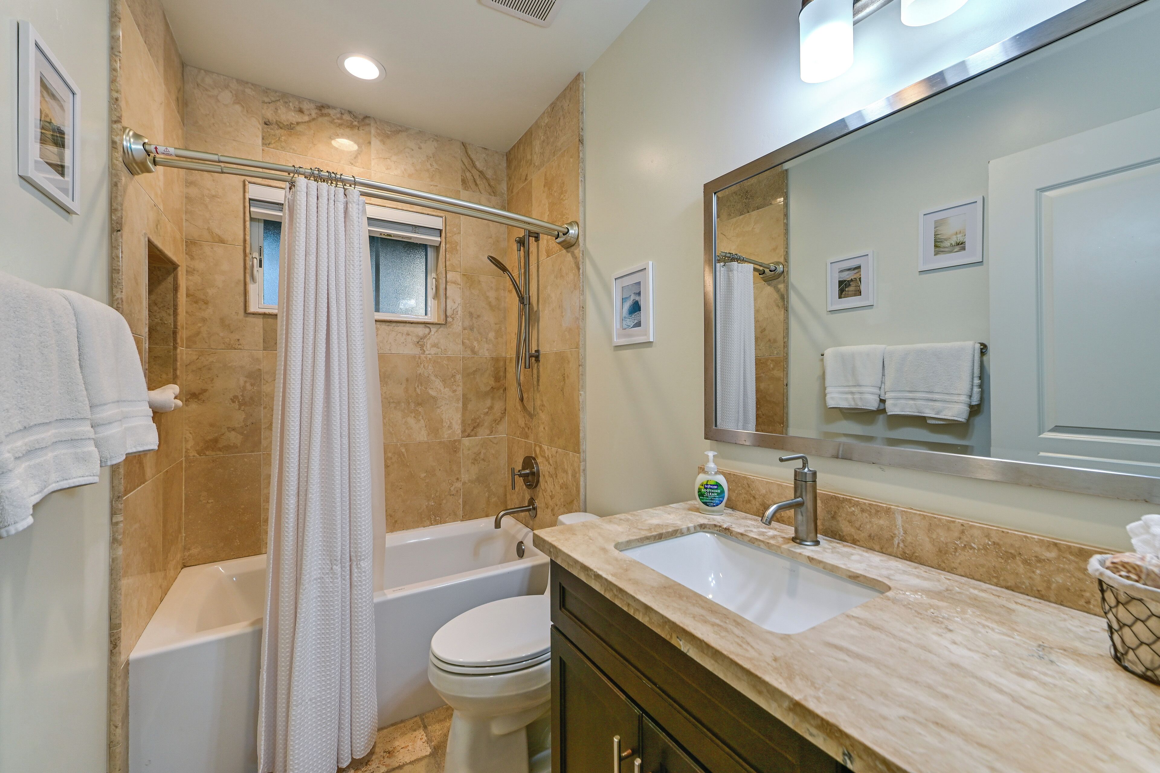 A bathroom with a bathtub, toilet, and sink.