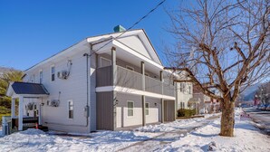 Une maison à deux étages avec un porche à l’avant et un garage.