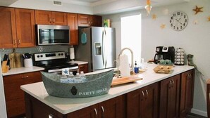 Une cuisine moderne avec des meubles en bois, des appareils en acier inoxydable et un îlot central.