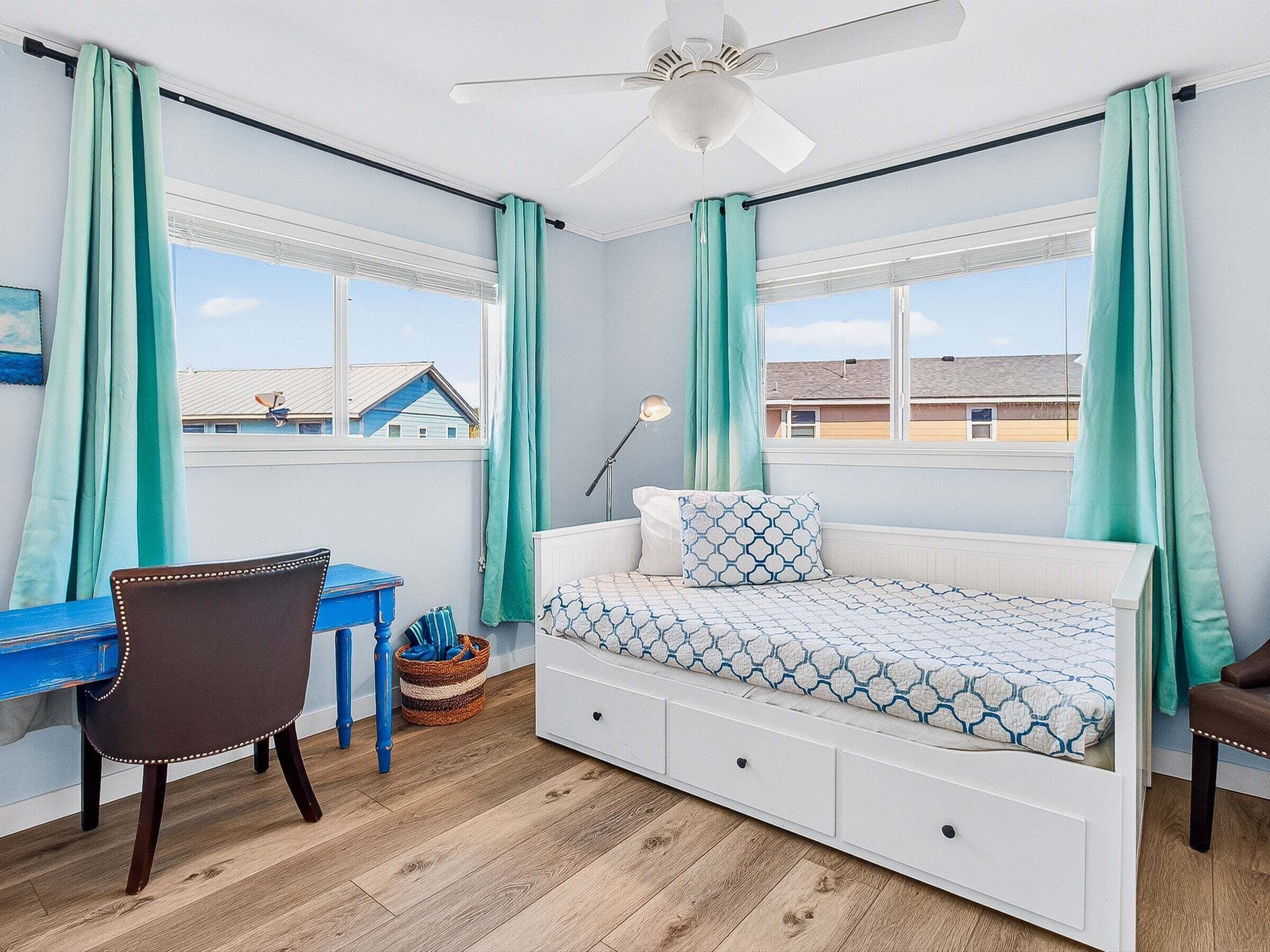 A bedroom with a bed, a desk, and a chair.