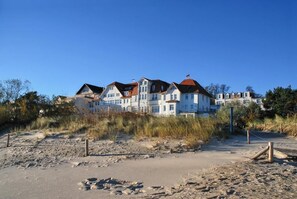 Propiedad frente a la playa con varias construcciones, una playa de arena y vegetación escasa.