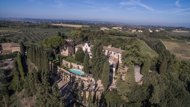 Vista aérea de una extensa propiedad con piscina, varias construcciones y amplios jardines.