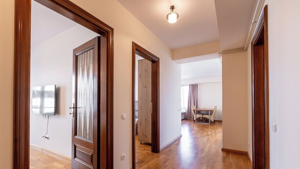 A hallway with wooden flooring and doors leading to different rooms. - AMBER apartments Large & Cozy Flat SIBIU  #24 (Sibiu)