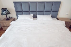Tabla de planchar con plancha y ropa de cama