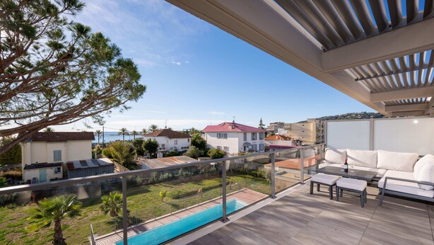 Une terrasse sur le toit avec une piscine, des espaces de détente en plein air et une vue sur le quartier environnant.