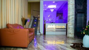 Een receptiebalie, een trap en een leren bank in de lobby.
