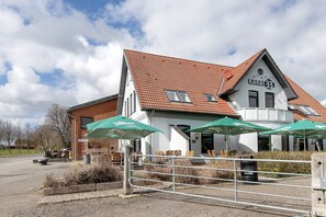 A building with a sign 'Kanal 33' and outdoor seating with umbrellas.