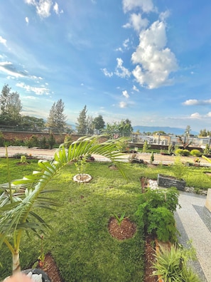 A landscaped garden with various plants and a paved walkway. - Ibigabiro Hotel (Kagano)