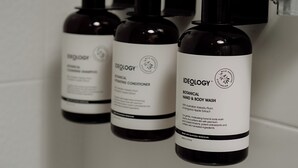 Three bottles of Ideology hand and body wash on a white surface.