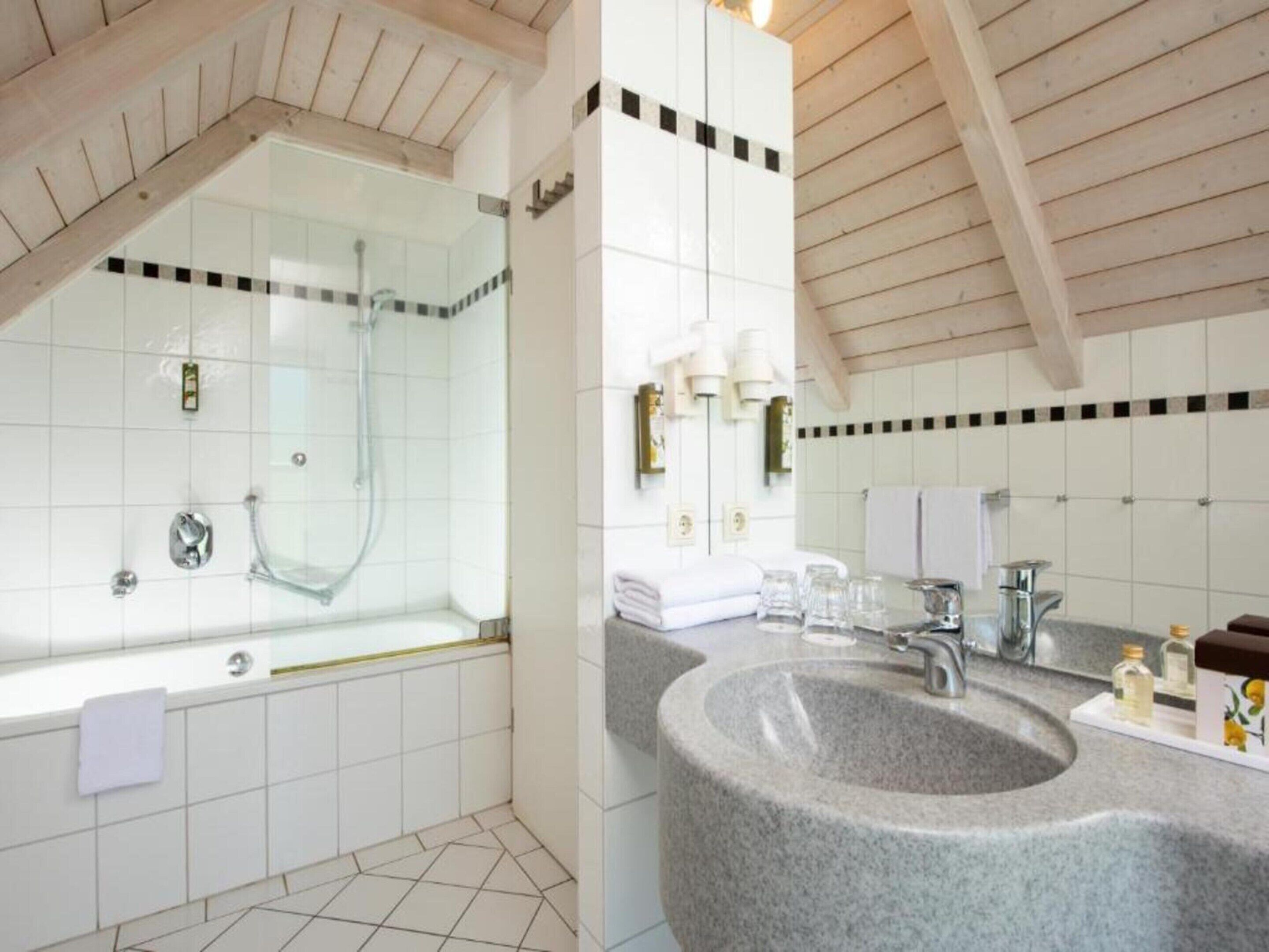 Un baño moderno con una bañera independiente, un lavabo grande y una zona de ducha.