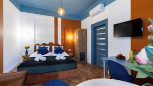 Ein Schlafzimmer mit Bett, Fernseher, Tisch und Stuhl.