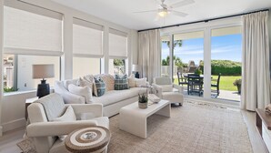A spacious living room with a large sofa, a coffee table, and a dining area with a table and chairs. - Gulf Front Condo | Private Beach Access | Walk to Rosemary & Alys (Inlet Beach)