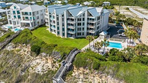 A multi-story hotel with balconies, a swimming pool, and a beach access bridge. - Gulf Front Condo | Private Beach Access | Walk to Rosemary & Alys (Inlet Beach)