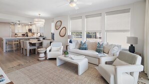 A modern living space with a kitchen, dining area, and seating area. - Gulf Front Condo | Private Beach Access | Walk to Rosemary & Alys (Inlet Beach)