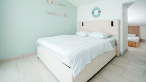 Un dormitorio con cama, cabecera y un adorno en la pared.