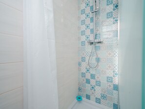 A shower with a tiled wall featuring a geometric pattern. - Nice apartment with terrace, close to the sea, sleeps 6 (Agde)
