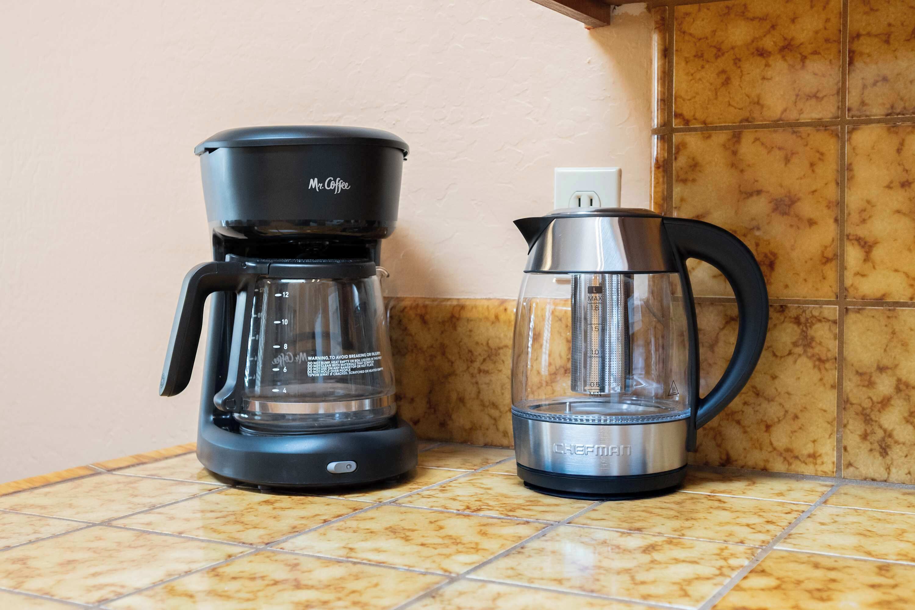 A coffee maker and a kettle on a kitchen counter.