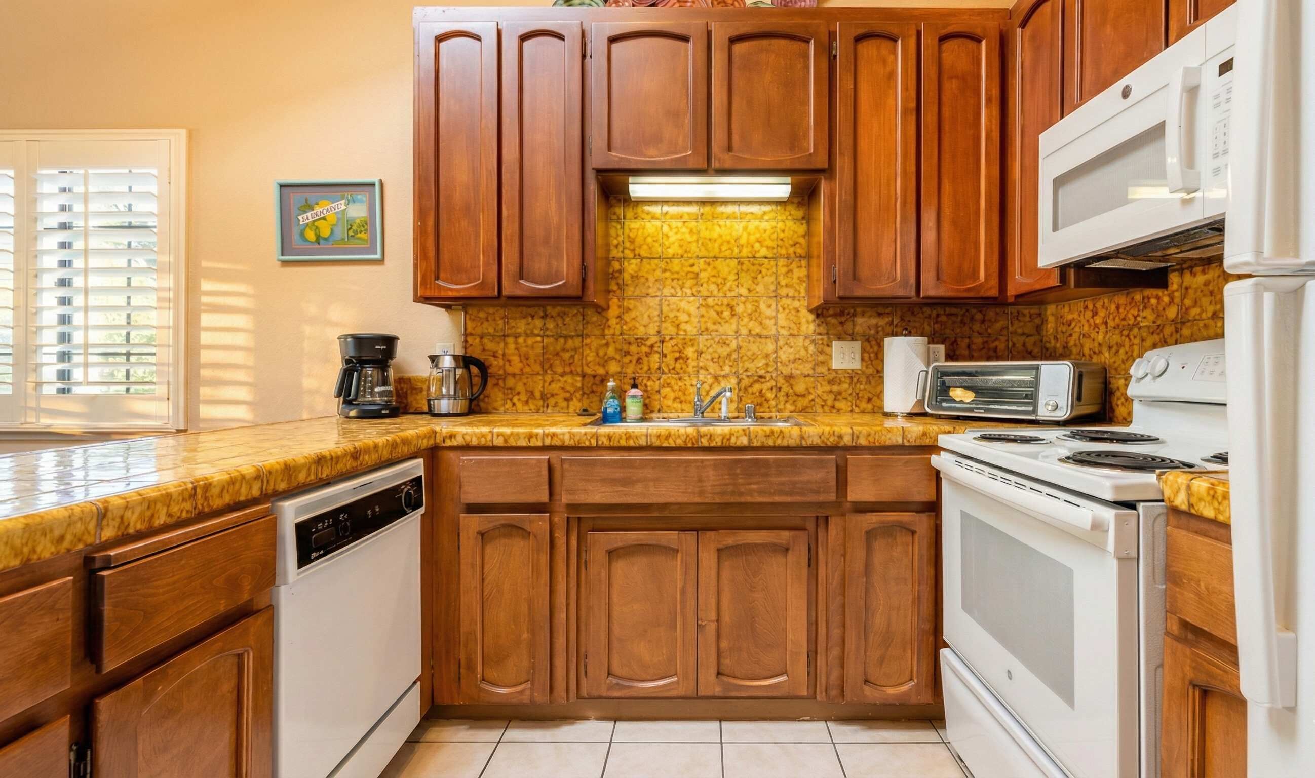 A kitchen with wooden cabinets, a built-in microwave, a toaster, and a dishwasher.