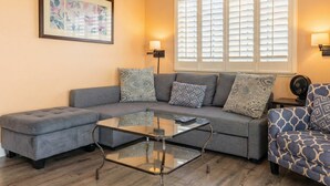 A living room with a grey sectional sofa, a glass coffee table, and patterned throw pillows. - Santa Cruz Retreat Near Beach with Free Parking (Santa Cruz)