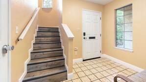 A staircase with wooden steps and white handrails, leading to a white door with a window above it. - Santa Cruz Retreat Near Beach with Free Parking (Santa Cruz)