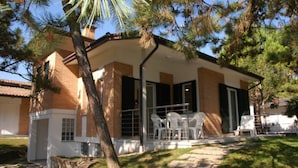 A two-story house with a covered patio area. - Cozy Retreat 500mt From the sea (Lignano Sabbiadoro)
