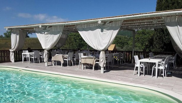 A poolside area with a covered seating area and a pool. - Apartment located within an Agriturismo with swimming pool in Maremma n.2 (Scansano)