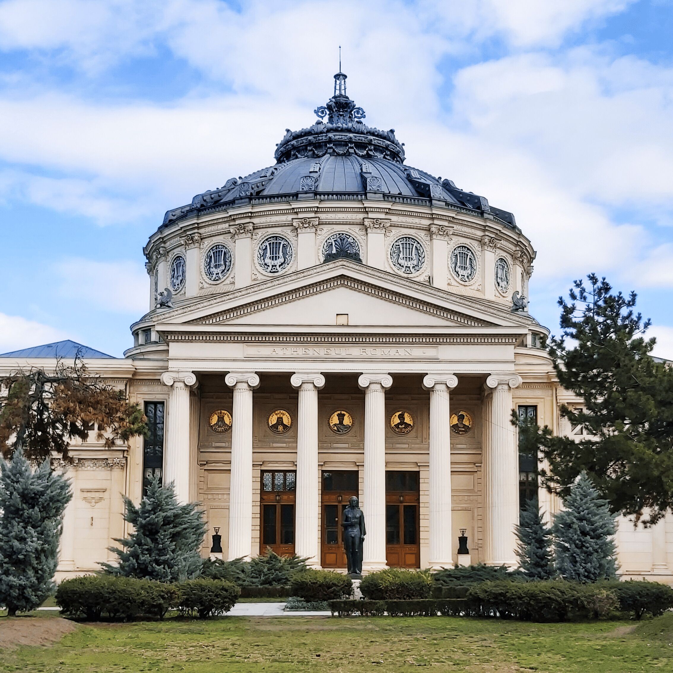 A classical building with a central dome, columns, and statues.