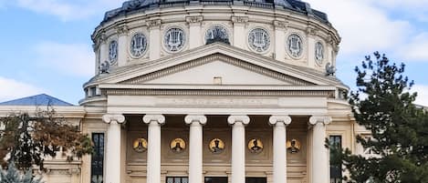 A classical building with a central dome, columns, and statues.