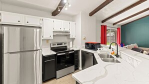 A modern kitchen with stainless steel appliances, white cabinetry, and a marble countertop. - Incredible Location | King Bed | Sleeps 14 (San Antonio)