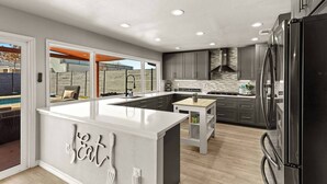 A modern kitchen with a central island, dark cabinetry, and stainless steel appliances. - Great Location-Huge Pool | Sleeps 14 | 2 King Beds (San Antonio)