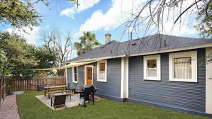 Une maison de plain-pied dotée d’un patio, d’un barbecue et d’une terrasse en bois.