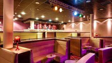Un interior moderno de restaurante con asientos tipo cabina y una zona de bar.