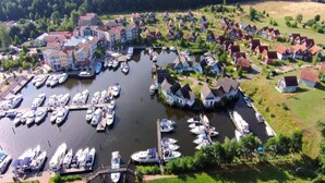An aerial view of a marina with numerous boats docked, surrounded by residential buildings and greenery. - Sunday Resort Marina 3-bedroom Apartment (Rheinsberg)