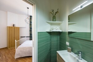 Comfort tweepersoonskamer | Badkamer | Een douche, een haardroger, handdoeken, zeep