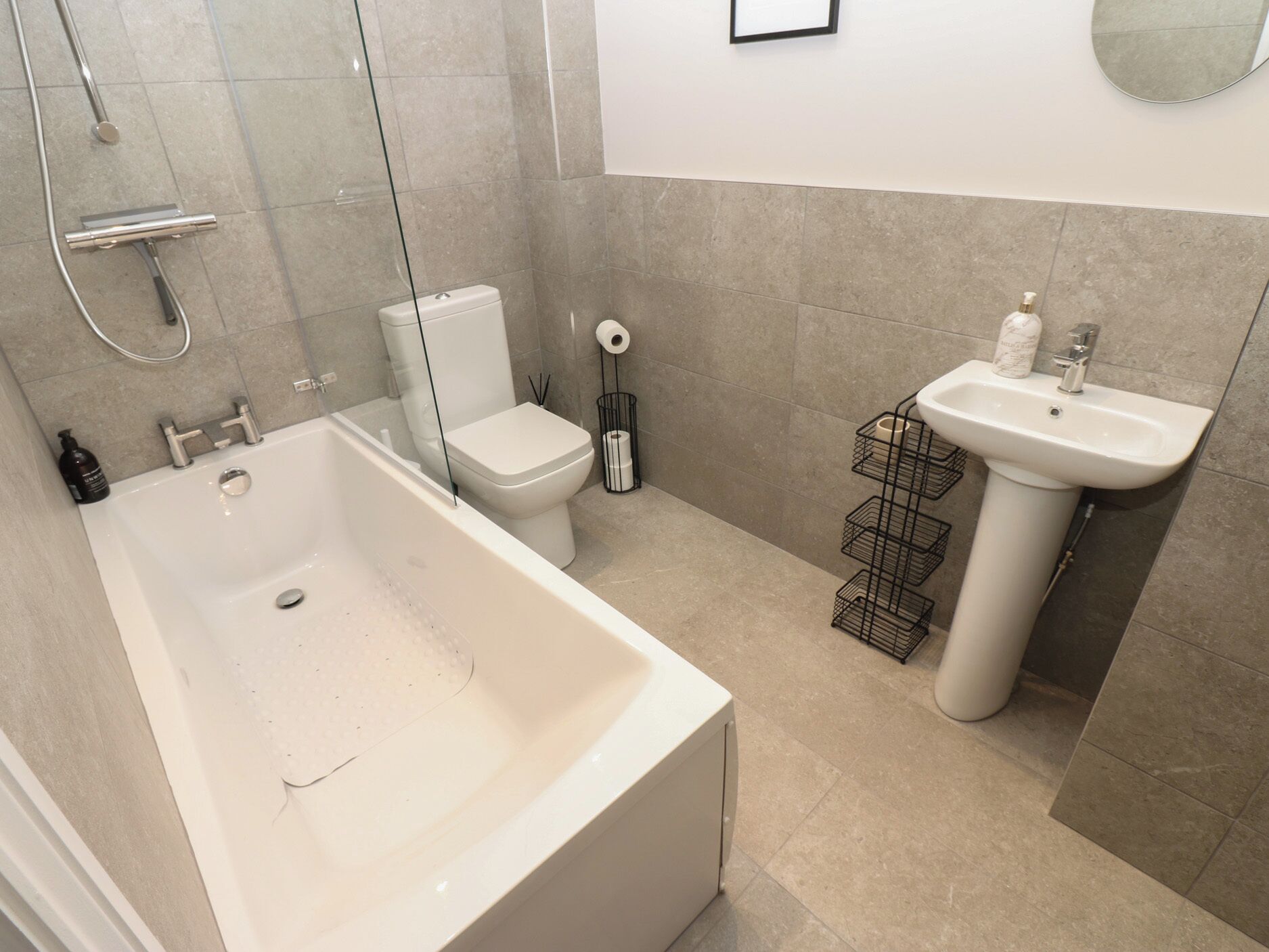 A modern bathroom with a bathtub, toilet, and sink.
