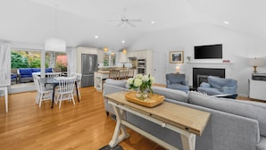 A spacious living area with a dining table, sofa, and TV. - Cape Cod Lake Retreat on Angus Way RPMS169 (Centerville)