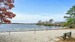 A beach with a bench and a house in the background. - Cape Cod Lake Retreat on Angus Way RPMS169 (Centerville)