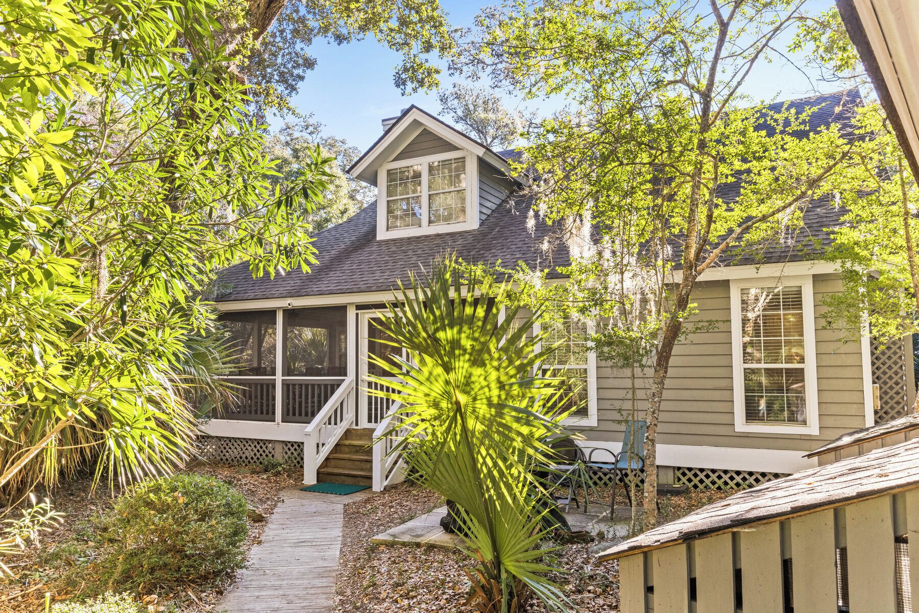 A house with a covered porch, a small front yard, and a pathway leading to the entrance.
