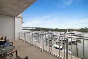 A balcony with a view of a marina and a bridge in the distance. - The Wharf 305 by Liquid Life (Orange Beach)