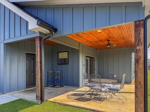 A covered patio area with a table and chairs, a ceiling fan, and a window. - Welcome to Camp Toledeaux (Many)
