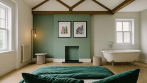 A room with a fireplace, a bathtub, and two framed pictures on the wall. - The Bridge - Penthouse Apartment (York)