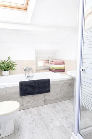 Een douche, een haardroger, handdoeken, toiletpapier