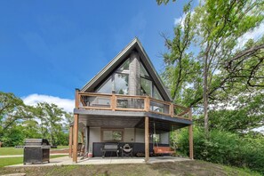 Ein modernes Haus mit Balkon, Grill und Schaukel.