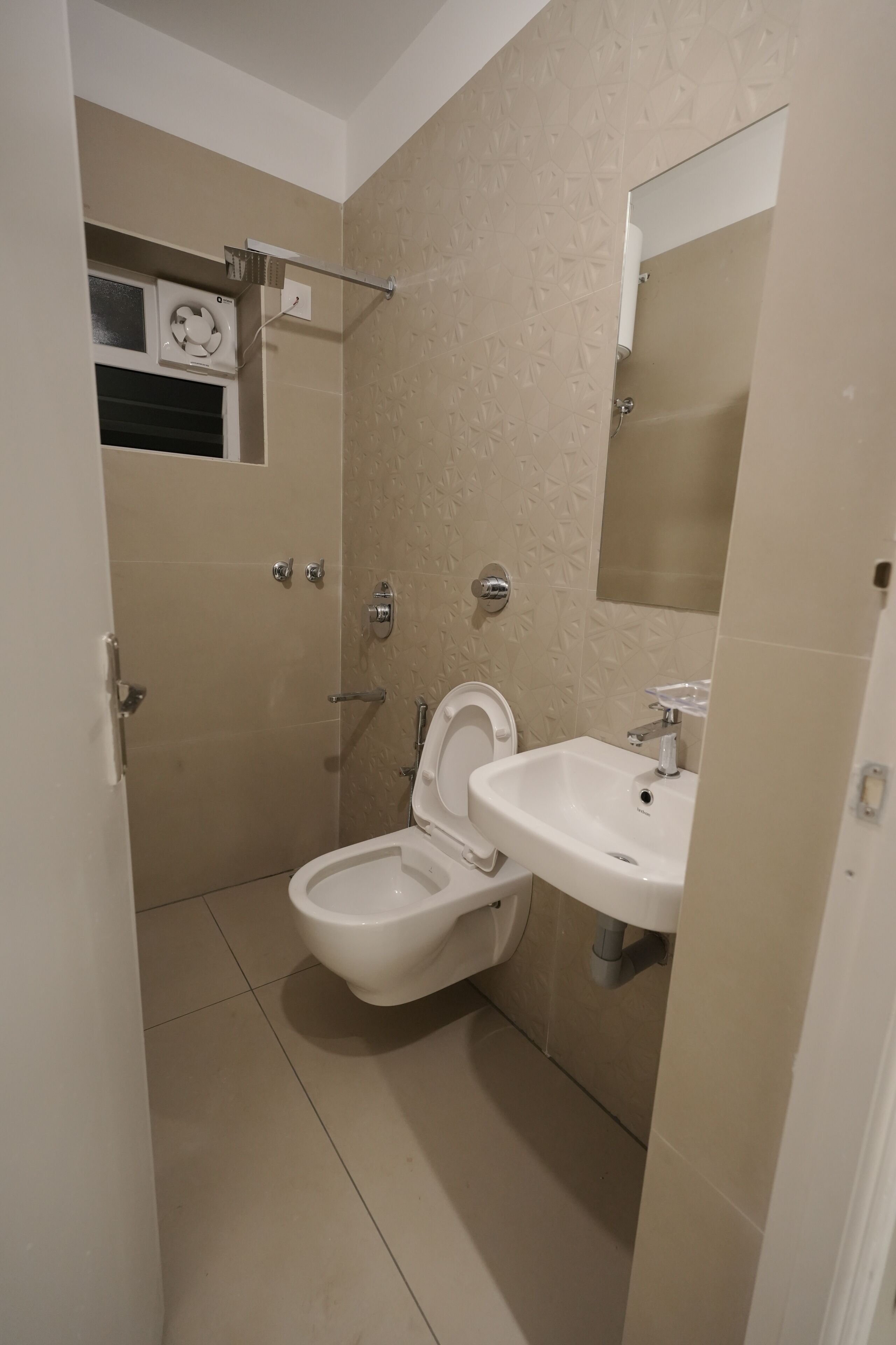 Et badeværelse med toilet, håndvask og brusebad.